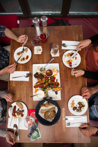 Gäste teilen sich Tapas-Gerichte an einem Tisch, Ansicht von oben